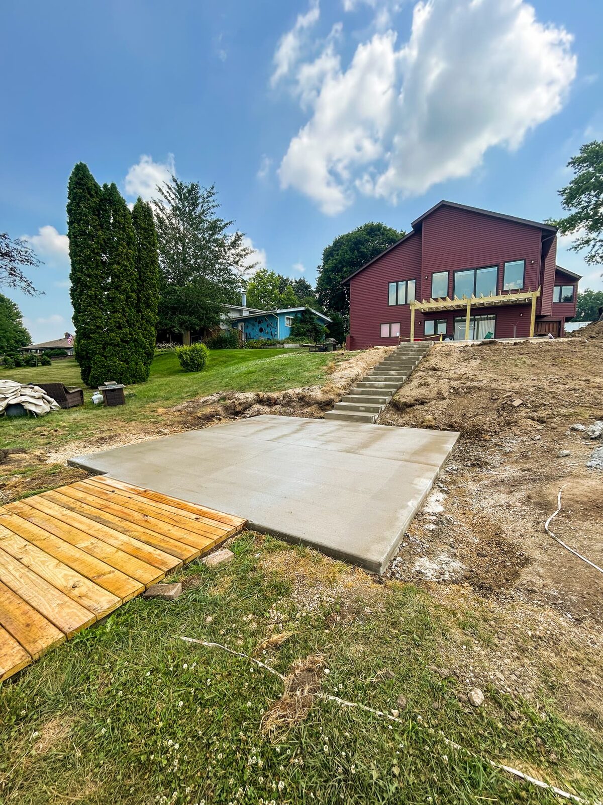 New backyard concrete slab with steps on a sloped lot